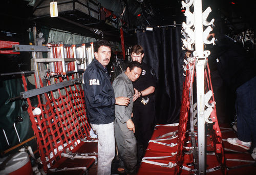 Noriega being excorted onto a U.S. aircraft carrier by DEA agents.